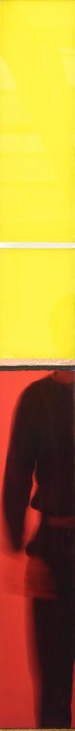 Tableau vertical très fin, en rouge et jaune.
On voit le reflet de la moitié du corps debout du photographe.